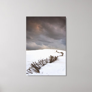 Ein defekter Zaun entlang einer Schnee Leinwanddruck