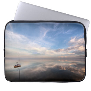 Ein einziges Segelboot auf dem ruhigen Wasser von Laptopschutzhülle