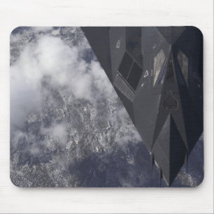 Ein F-117A Nighthawk fliegt hoch über das mountai Mousepad