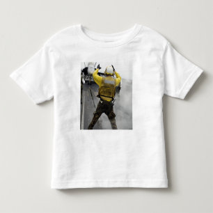 Ein Flugzeugdirektor signalisiert einer F/A-18C Kleinkind T-shirt