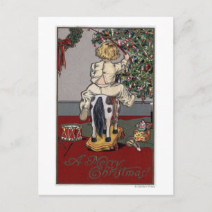 Ein frohes Weihnachtskid auf einem Rockpferd Feiertagspostkarte