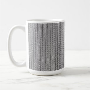 Ein geometrisches, weißes und graues Muster füllt Kaffeetasse