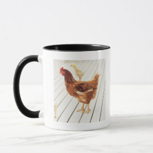 Ein Huhn und zwei Küken auf einem hölzernen Bode Tasse