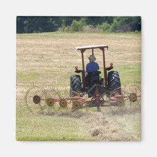 Ein junger Junge fährt einen Traktor zur Ernte Magnet