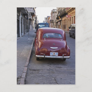 Ein klassischer alter roter Peugeot, der auf einer Postkarte