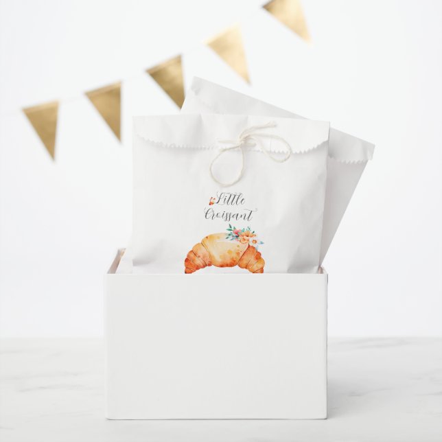 Ein kleines Croissant ist unterwegs mit einer Baby Geschenktütchen (Party)