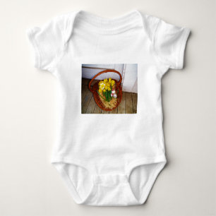 Ein Körbchen mit gelben Eizellen und blumengeschmü Baby Strampler