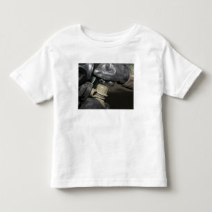 Ein Marinesoldat fügt ein trinkendes Rohr in sein Kleinkind T-shirt