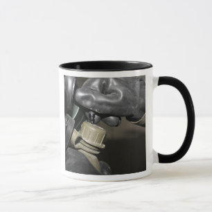 Ein Marinesoldat fügt ein trinkendes Rohr in sein Tasse