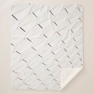 Ein Muster weißer geometrischer Formen in einer Fa Sherpadecke