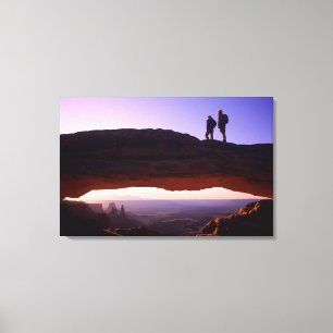 Ein paar beobachten Sonnenaufgang vom Mesa Arch in Leinwanddruck