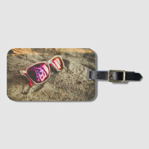 Ein Paar moderne Sonnenbrille auf dem Strand Gepäckanhänger