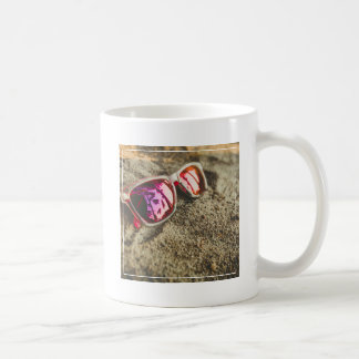 Ein Paar moderne Sonnenbrille auf dem Strand Kaffeetasse