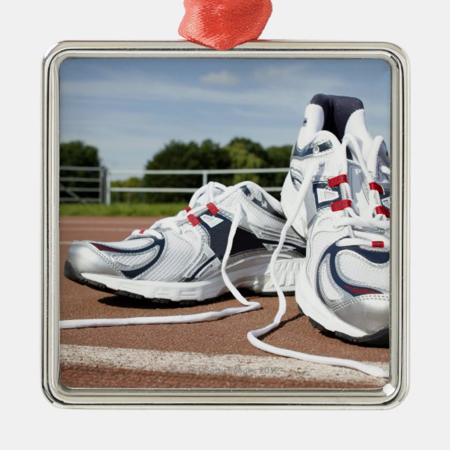 Ein Paar neue weiße laufende Trainer werden Silbernes Ornament (Vorne)