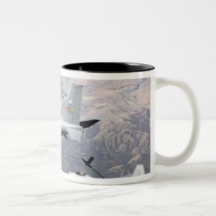 Ein Raubvogel F-22 empfängt Brennstoff von einem Zweifarbige Tasse