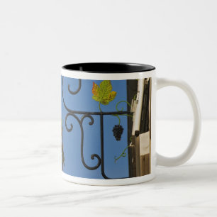Ein schmiedeeisernes Schild, das das Thema veransc Zweifarbige Tasse