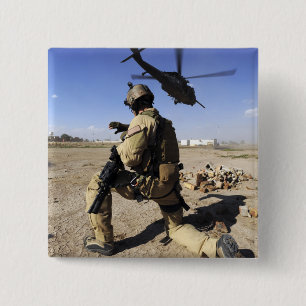 Ein Soldat leitet Sicherheit für ein HH-60 Button