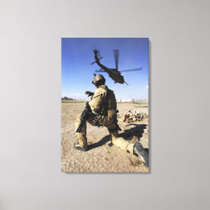 Ein Soldat leitet Sicherheit für ein HH-60 Leinwanddruck