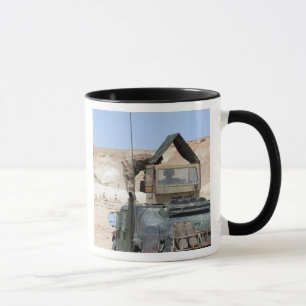Ein Soldat weist einen irakischen Soldaten an Tasse