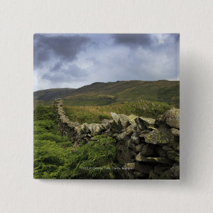 Ein Steinzaun durch Felder Button