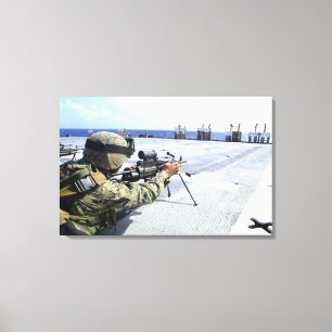 Ein US-Marinesoldat, der seine Waffe justiert Leinwanddruck