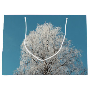 Ein weißer Wildbaum gegen wolkenlosen blauen Himme Große Geschenktüte