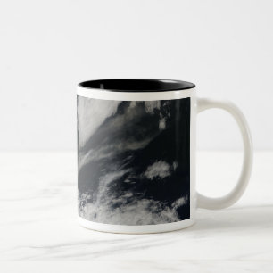 Eine blasse graue Aschenfeder brennt vom Gipfel Zweifarbige Tasse