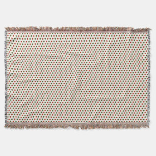 Eine gewebte Decke mit roten und grünen Tupfen 
