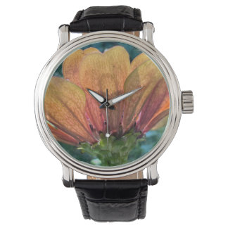 Eine hinterleuchtete orange-zinnische Blume Armbanduhr