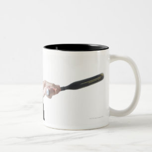 eine hübsche junge kaukasische Frau trägt a Zweifarbige Tasse