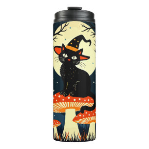 Eine kleine schwarze Hexenkatze sitzt auf einem Gi Thermosbecher