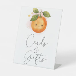 Eine kleine Süsse orangefarbene Babyduschkarten un Sockelschild