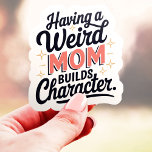 Eine komische Mama baut Charakter Funny Vinyl Aufkleber<br><div class="desc">Dieser lustige und relativierende Aufkleber ist perfekt für jeden, der eine sonderbare oder unkonventionelle Mutter hat! Mit dem Satz "Eine merkwürdige Mama baut Charakter" ist dieses Design eine leichtere Hommage an jene Mütter, die ihre einzigartige Persönlichkeit annehmen. Dieser Aufkleber aus haltbarem Vinyl eignet sich hervorragend für Laptops, Wasserflaschen und vieles...</div>