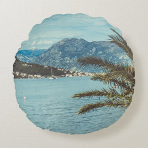 Eine Landschaft mit Bergen und Palmen Rundes Kissen