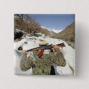 Eine Mujahadeen-Garde geht mit dem US-Militärkomma Button