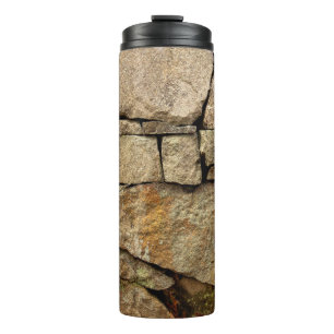 Eine Steinmauer aus Kopfsteinpflaster-Hintergrund Thermosbecher