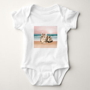 Eine süßere gestreifte Katze sitzt am Strand bei S Baby Strampler