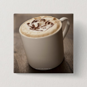 Eine Tasse Cappuccino mit geschmolzenem Kaffee Button