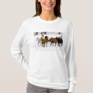 Eine Winterlandschaft mit galoppierenden Pferden T-Shirt