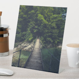 Einfache Hängebrücke über den Fluss Idrijca, Slove Sockelschild