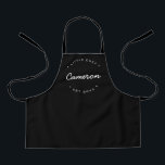 Einfache Personalisierte Bezeichnung Jahr Kleiner  Schürze<br><div class="desc">Personalisieren Sie diese schwarze Schürze mit dem Namen des "kleinen Koch". Moderne Typografie,  weißer Schriftart mit individualisierbarem Text für das etablierte Jahr und den etablierten Namen. Förderung kulinarischer Fähigkeiten in jungen Jahren. Dieses nachdenkliche Geschenk wird der Lebensmittelexperte der Familie in Erinnerung behalten,  wenn sie wachsen.</div>