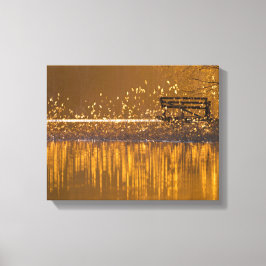 Einsame Bank am See im goldenen Licht Leinwanddruck