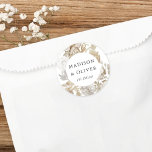 Elegant, erthy, Floral White Gastgeschenk Hochzeit Runder Aufkleber<br><div class="desc">Dieses hübsche Lieblingstickerdesign zeichnet sich durch schöne neutrale Farbfloralen mit Ihren Namen und Hochzeitstermin aus. Dieses zeitlose Design ist eine ausgezeichnete Wahl für viele Arten von Veranstaltungen,  von klassisch bis boho. Individuell gestaltete Vorzugsetiketten ergänzen Ihren Hochzeitsempfang oder Ihr Brautparty ...  und fügen diese besondere Touch hinzu!</div>