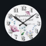 Elegante florale Hochzeit Soft Botanical Romance Runde Wanduhr<br><div class="desc">Dieses elegante Design besticht durch eine anmutige Anordnung von handbemalten Blumenelementen in sanften Pastelltönen. Das Design zeigt zarte weiße Knospen, sanfte blaue Blüten und eine pulsierende magnolische Blume, alles Set vor einem weichen grauen Hintergrund. Die minimalistischen Blumenakzente verleihen dem Ganzen ein Gefühl zeitloser Schönheit und Romantik, perfekt für Paare, die...</div>