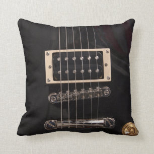 Elegante schwarze E-Gitarre reiht Wurfs-Kissen auf Kissen