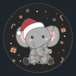 Elephant Christmas Snow Winter Animals Elephants C Runder Aufkleber<br><div class="desc">Der Elefant zu Weihnachten mit Feenlicht. Hübsche Tiere mit Geschenken und Schnee für den Urlaub. Auch lustig für Weihnachten im Juli. Elefanten sind niedliche Tiere und perfekt zu Weihnachten.</div>