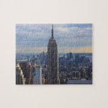 Empire State Gebäude<br><div class="desc">Dramatisches Foto der ikonischen New Yorker Sehenswürdigkeit, des Empire State Gebäude, gegen einen blauen Himmel mit weißen Wolken. Foto: Bobby Mikul.</div>