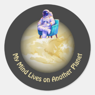 Entspannter Astronaut sitzt auf einem Planeten Runder Aufkleber
