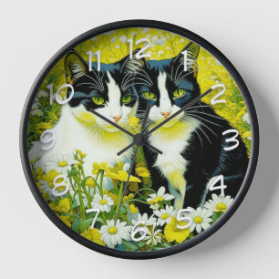 Entzückende Katzen sitzen auf einem Feld mit Gänse Uhr