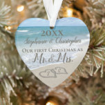 Erste Weihnachten Herz Beach Hochzeit Mr. Mrs. Ornament<br><div class="desc">Hübsche personalisierte, herzförmige Ornament, um sich an Ihre erste Weihnachtszeit erinnern wie Mr. und Mrs. Erste Weihnachten zusammen mit zwei ineinander greifenden Strand Hochzeitsherzen im Sand gezeichnet macht eine elegante tropische Ozean Küste nautische Theme Hochzeit, passendes Set von Gegenständen. Hübschen türkisfarbene Wellen, die am Ufer und am pastellblauen Himmel abstürzen....</div>